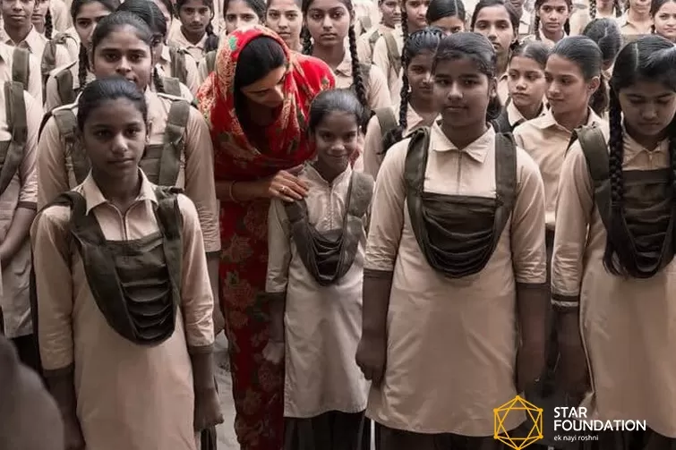 A woman from the Star Foundation is standing in front of a group of girls.