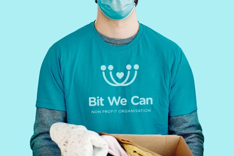 A man wearing a mask holding a box of clothes that bit.